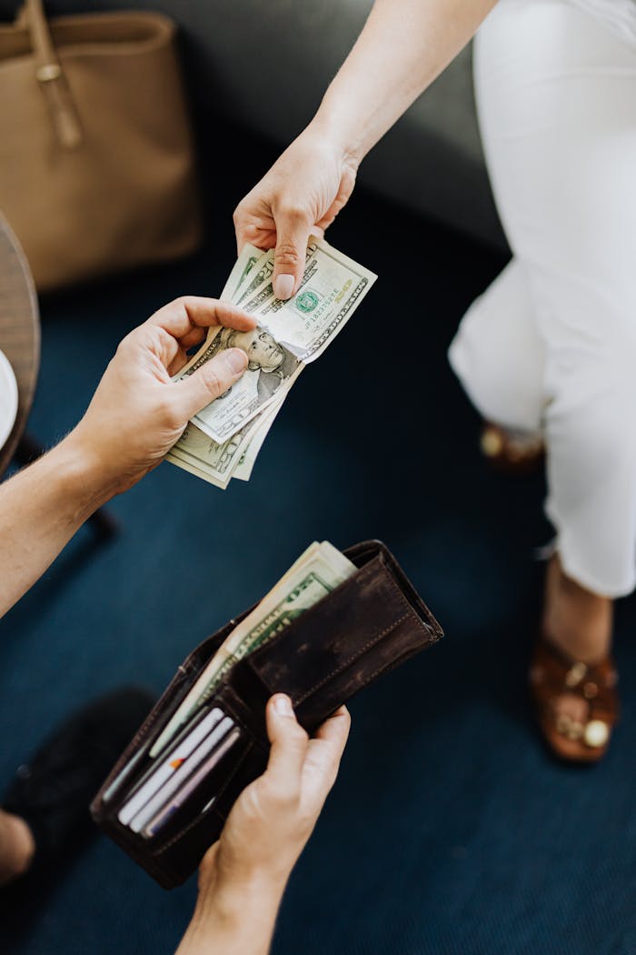 journey Close-up of hands exchanging cash, representing a financial transaction or payment.