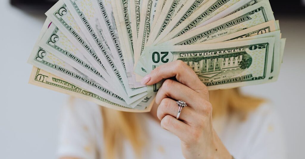 pexels photo 4968649 4968649 A person holding a fan of US dollar bills, symbolizing wealth and financial success.
