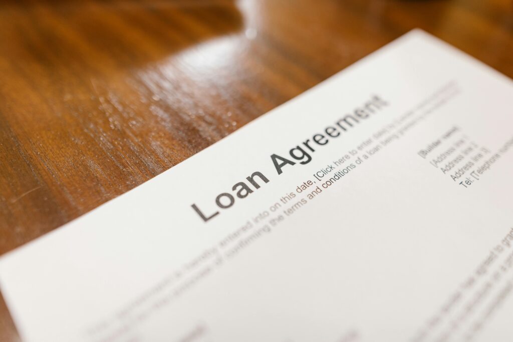 pexels photo 7841821 7841821 Detailed loan agreement document close-up on a wooden table representing legal and financial concepts.
